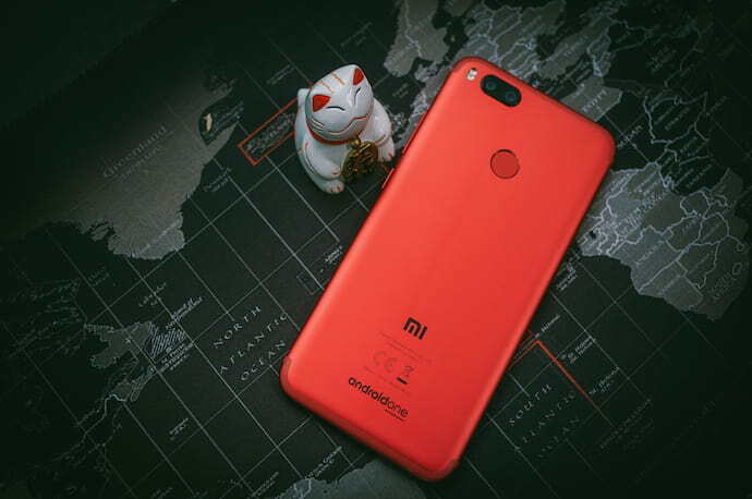 Celular xiaomi vermelho em cima de mapa mundial