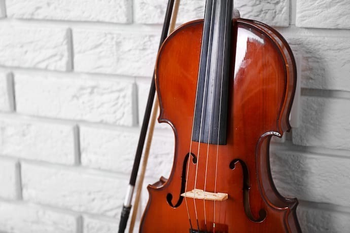 Violino em fundo de tijolos brancos