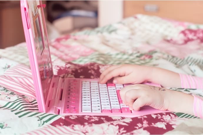 Criança brincando com laptop infantil 