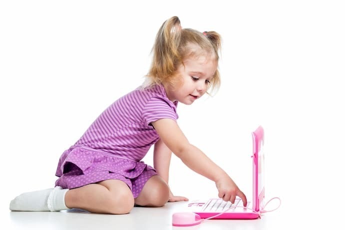 Menina brincando com laptop infantil