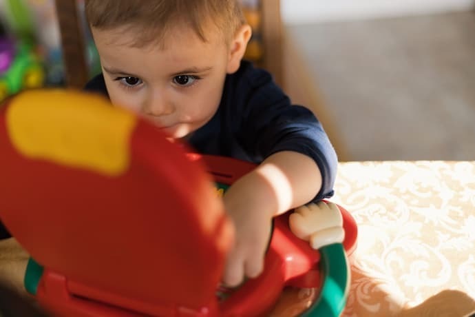 Criança brincando com laptop infantil 