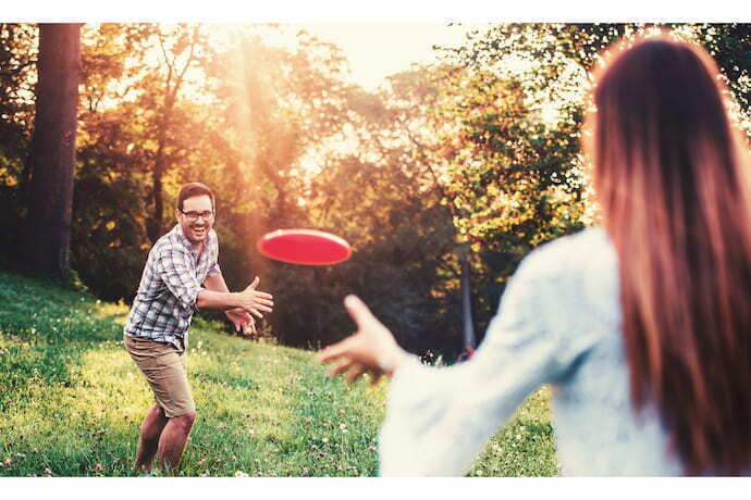 Um homem e uma mulher jogando frisbee