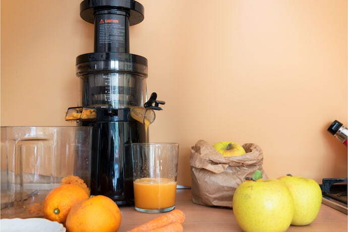 Centrífuga de sucos e algumas frutas na bancada da cozinha