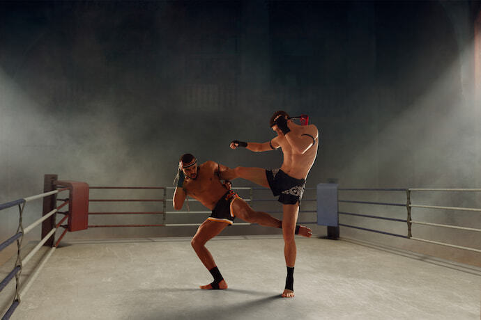 Dois homens treinando muay thai com caneleira