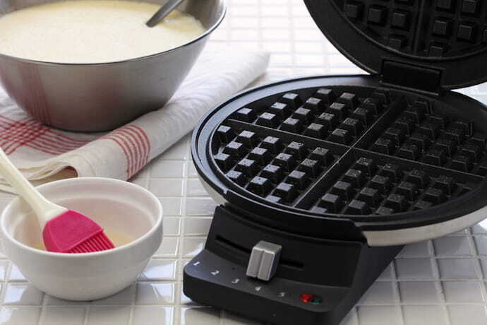 máquina de waffle e recipiente branco ao lado