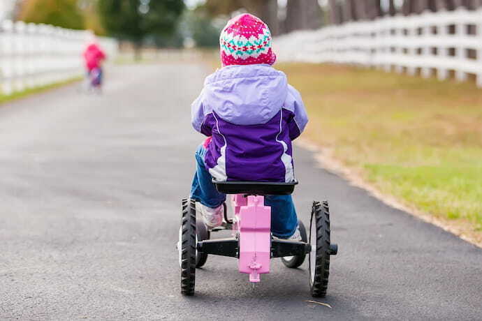 Menina em carrinha com pedal.