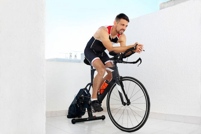 Ciclista treinando em bike em casa.