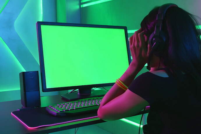 Menina jogando em mesa gamer.