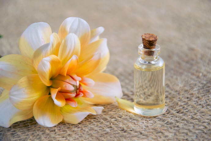 Perfume ao lado de flor amarela