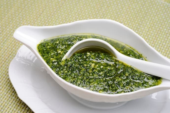 Molho pesto dentro de recipiente branco