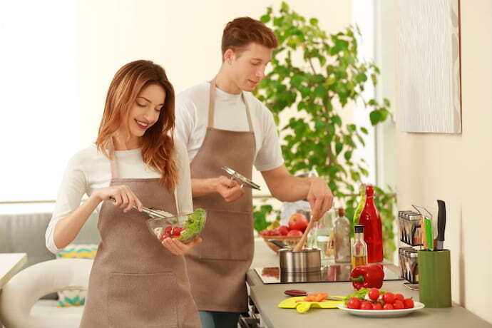 Casal usando avental de cozinha.