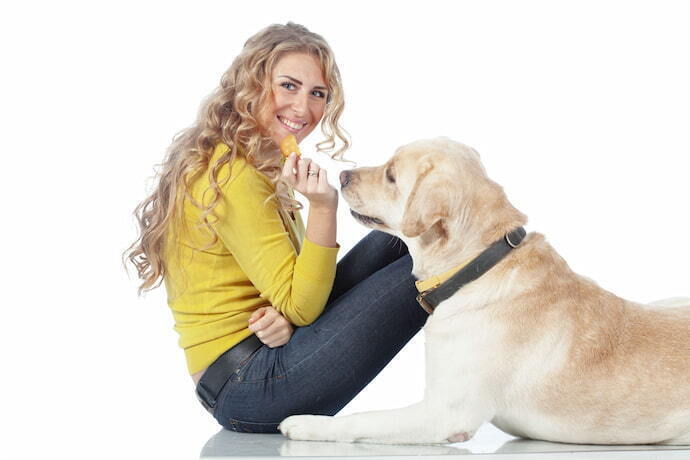 Mulher sentada com cachorro deitado. 