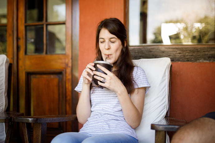 Mulher tomando chimarrão em cuia.