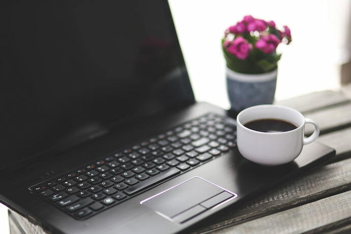 Notebook com café em cima.