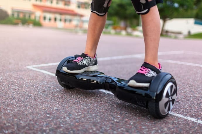 Menina andando em hoverboard preto.