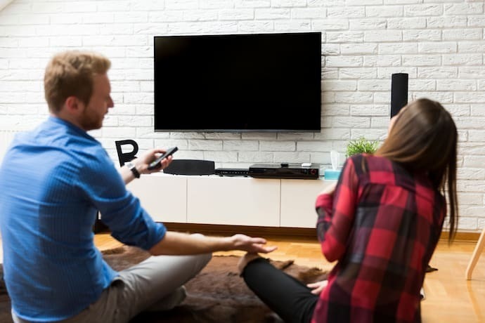 Casal ligando TV com Alexa.