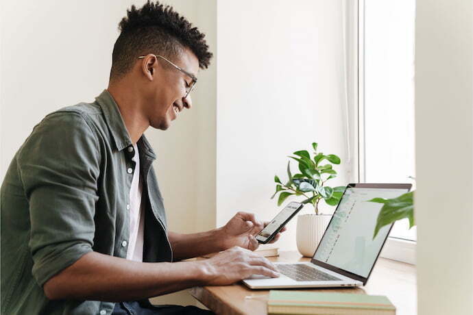 Homem feliz com notebook positivo.