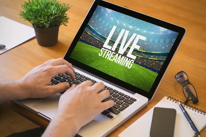 Pessoa mexendo em notebook com live streaming.