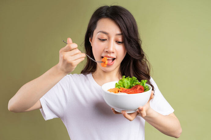 Pessoa comendo salada.