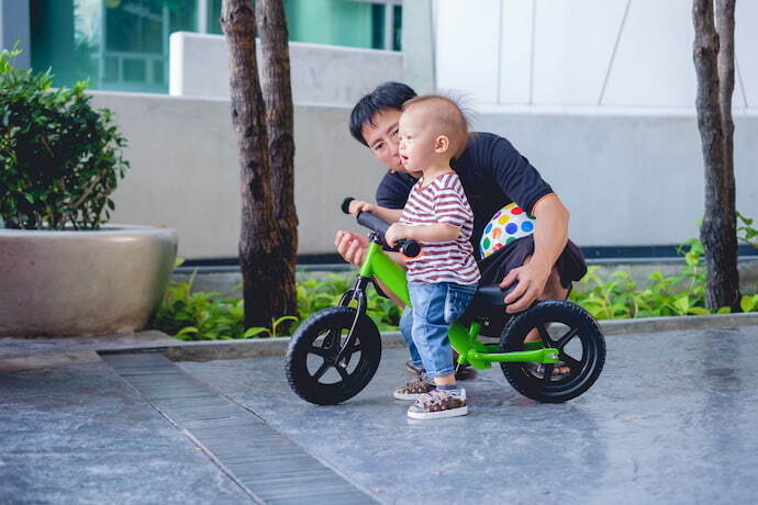 Criança brincando com triciclo infantil