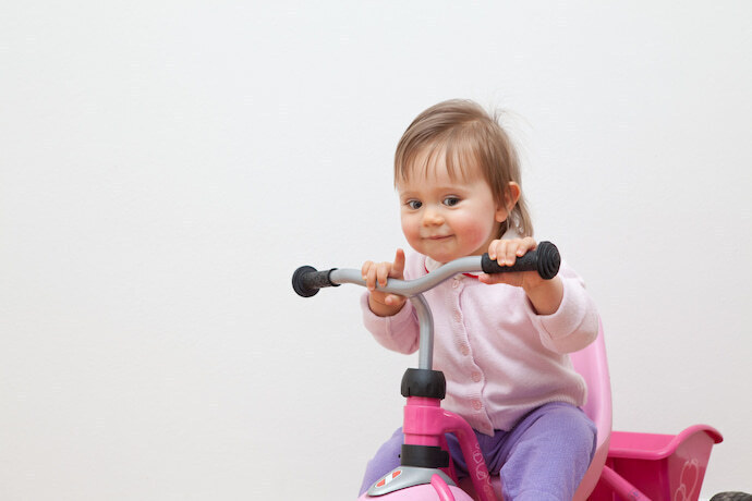 Criança brincando com triciclo infantil