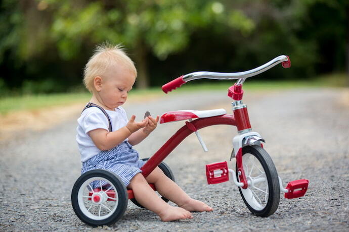 Criança brincando com triciclo infantil