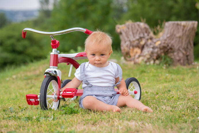 Criança brincando com triciclo infantil