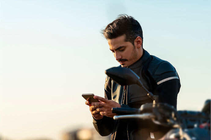 Motociclista segurando celular