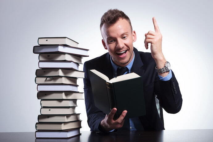 Homem de terno lendo Livro de PNL.