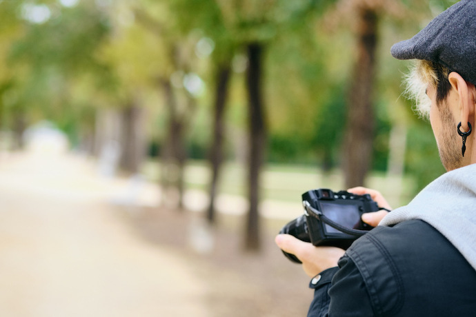 homem olhando uma foto na câmera mirrorless