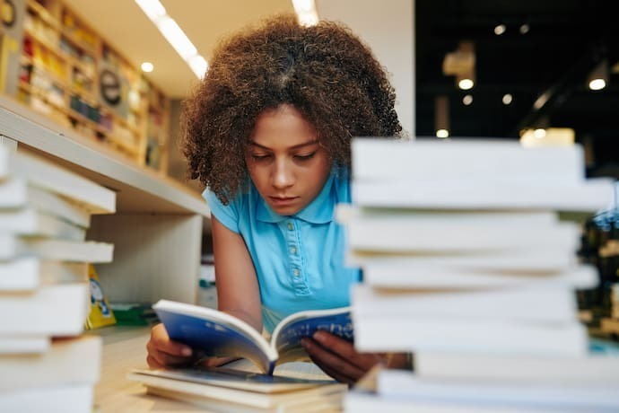 Garota lendo livro deitada no chão