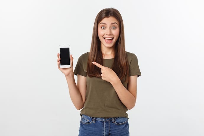 Mulher sorrindo e segurando seu celular desligado