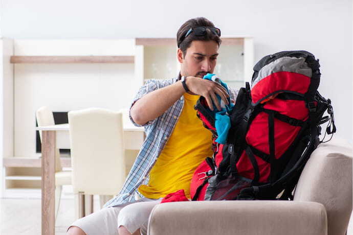 Homem arrumando a mochila para viagem