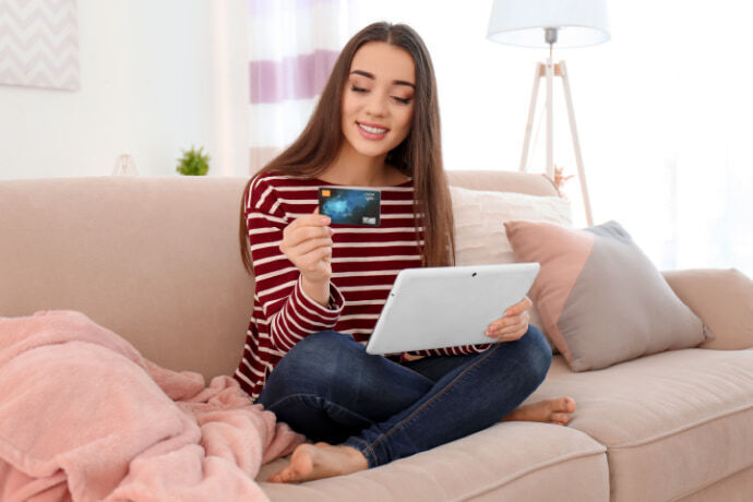 Mulher sorridente fazendo uma compra online com garantia 