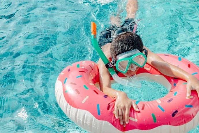 Indivíduo com boia e óculos de natação em uma piscina