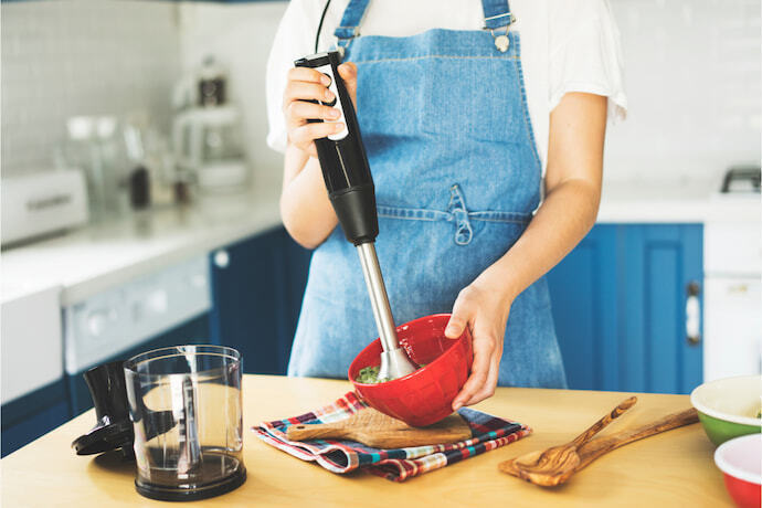 Fazendo purê de vegetais com um mixer de mão.