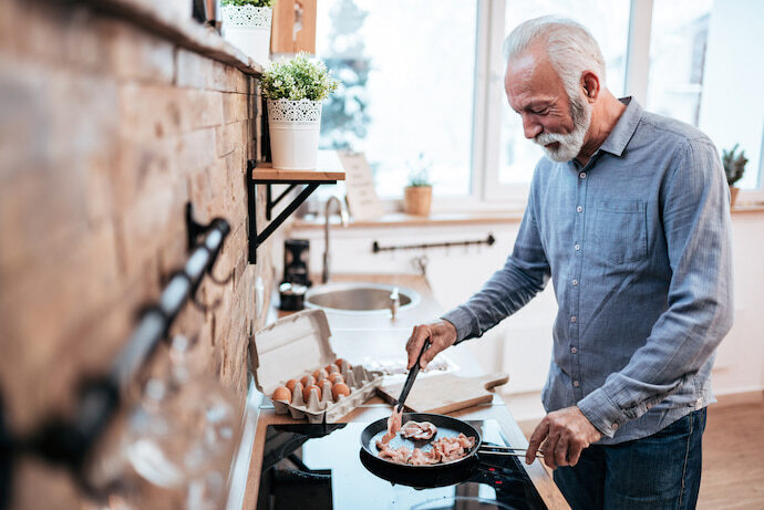 Um senhor cozinhando 