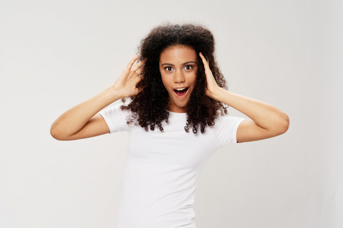 Mulher com cabelo encaracolado em fundo branco.