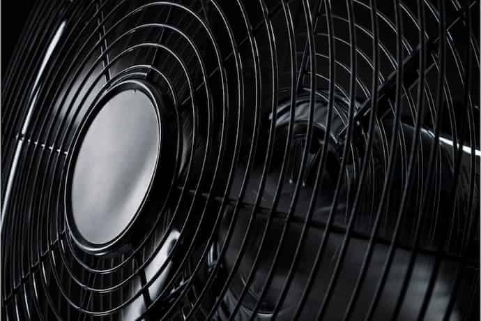 Ventilador com grades pretas visto bem de perto