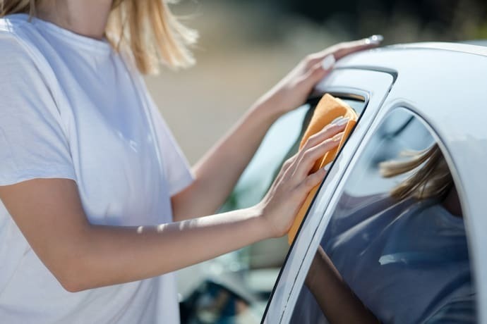 Mulher passando pano no carro