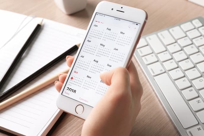 Alguém com Iphone na mão vendo o calendário