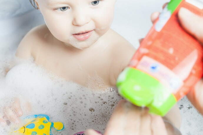 Mulher pegando shampoo para passar no bebê