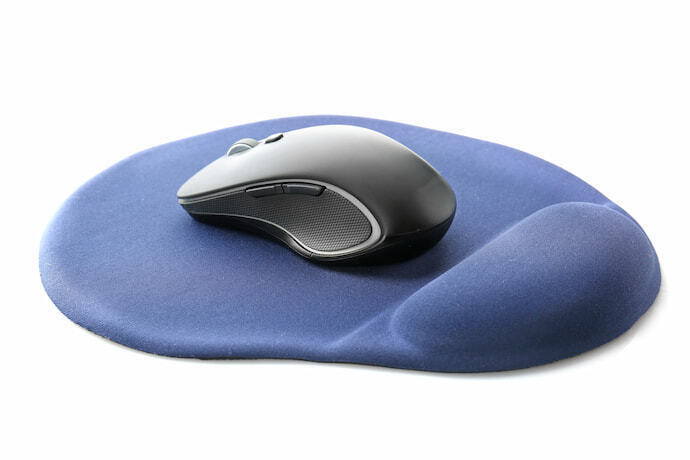 Mousepad e mouse sobre superfície amarela 