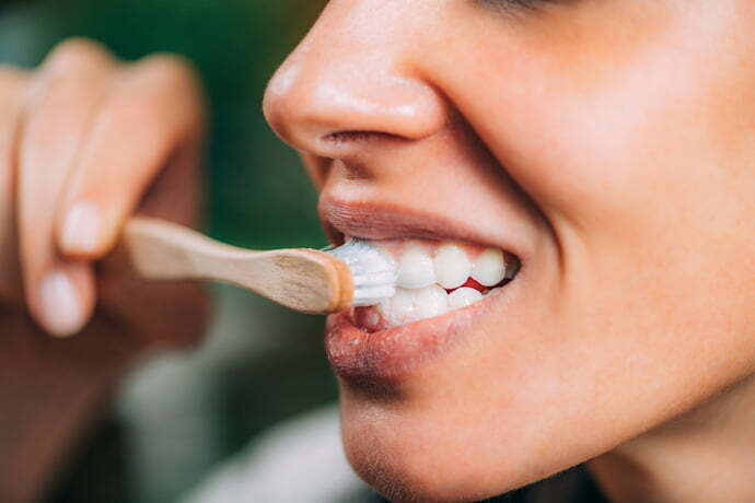 Uma mulher escovando os dentes