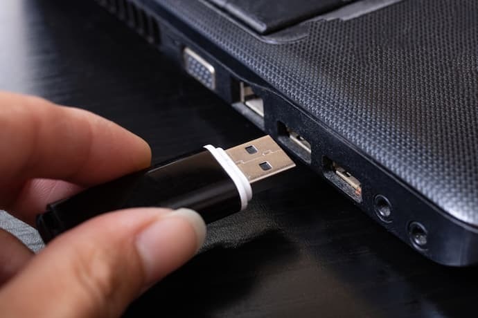 Alguém colocando o pen drive no notebook