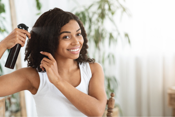 Mulher usando leave-in em spray no cabelo