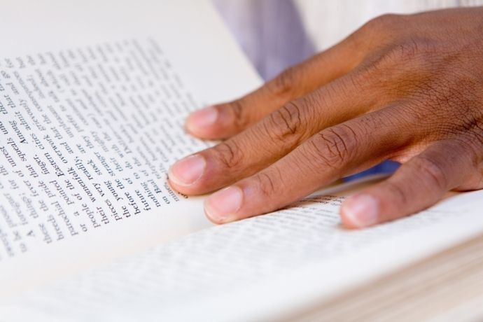 Homem foleando páginas de livro