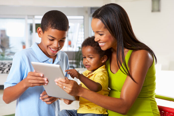 Mãe e dois filhos mexendo no tablet