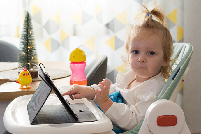 Menina mexendo no tablet com capinha de proteção 