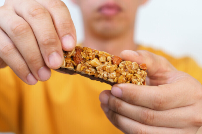 Indivíduo segurando uma barra de proteína